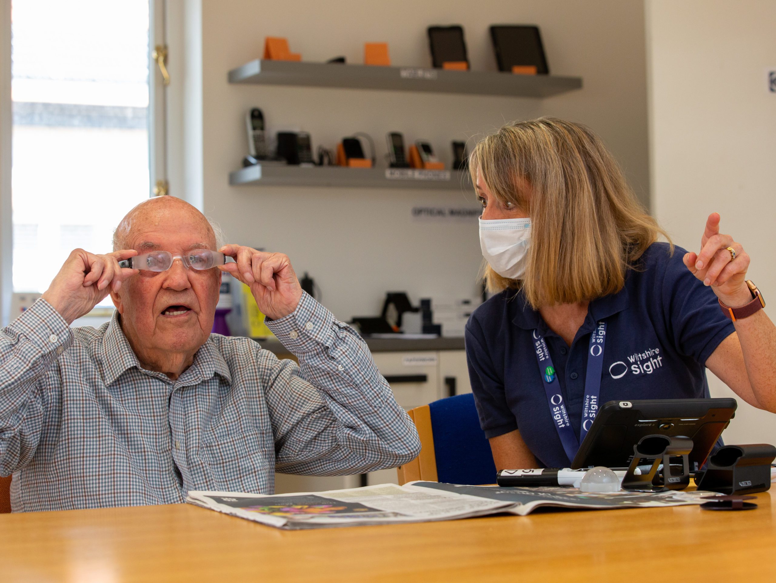 Sight Loss Advisor sat at a table in the Devizes resource centre with a client. Thye are tring out various types of magnification.