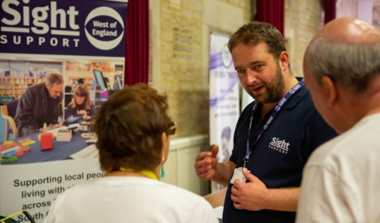 Community Sight Loss Advisor for Sight Support talking to a couple of people at an information event.