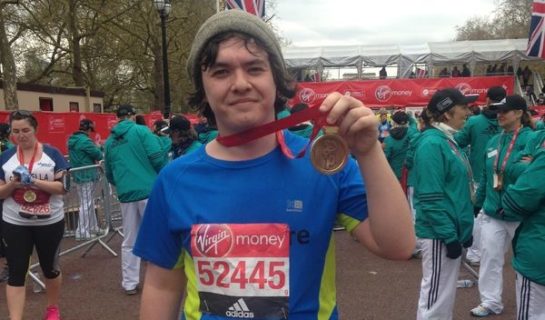 Photo of participant showing medal to camera