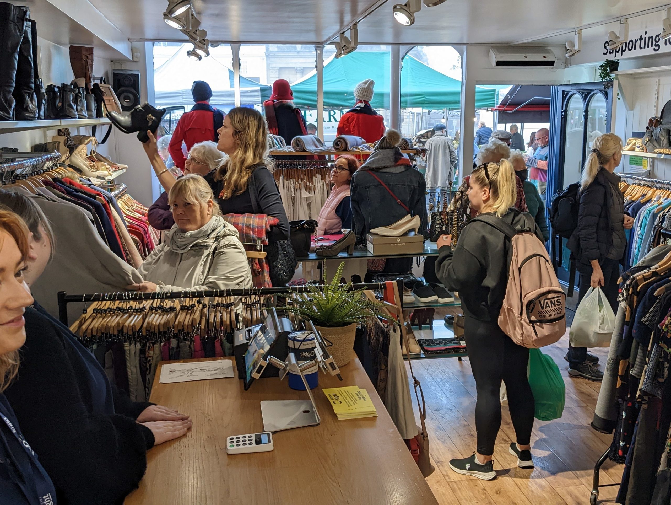 The inside of the shop with our counter and many customers viewing the clothes