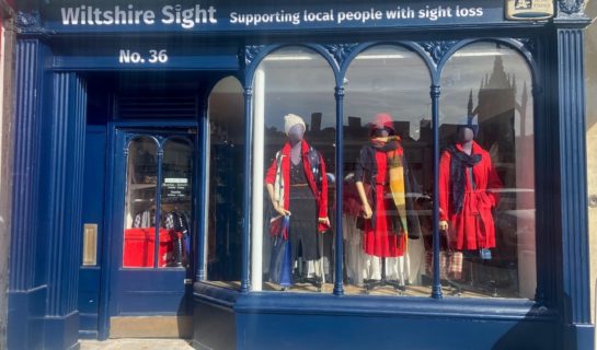 front of our Devizes Charity shop, the large window is framed by dark blue woodwork and there are 3 panes of glass each featuring a different mannequin