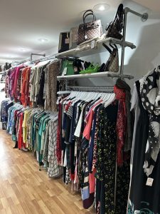 A colourful display of ladies clothing and accessories on rails against the wall