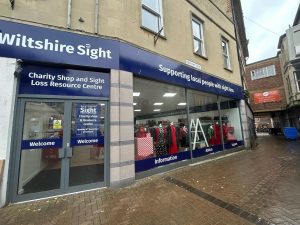 The outside of our Trowbridge charity shop, we have  dark blue signage above our large window.